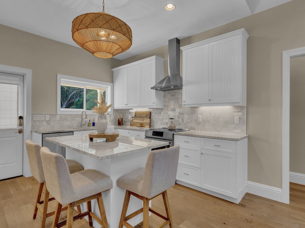 548 Conn Way Vero Beach, FL 32963 - Photo 11 of 35 a kitchen with a table chairs and white cabinets