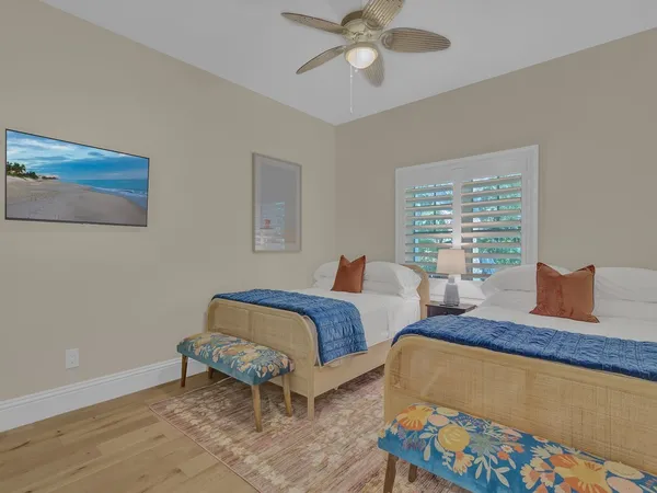 a bedroom with two beds and painting on the wall