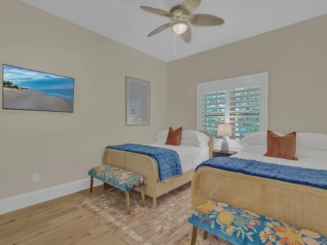 a bedroom with two beds and painting on the wall