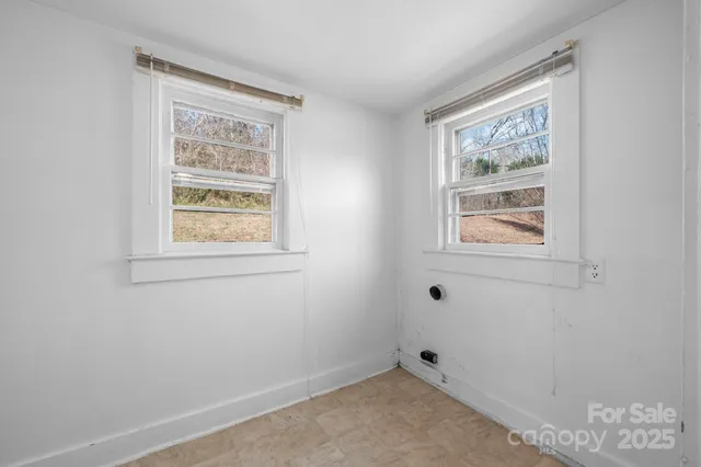 a room with window and painting on the wall