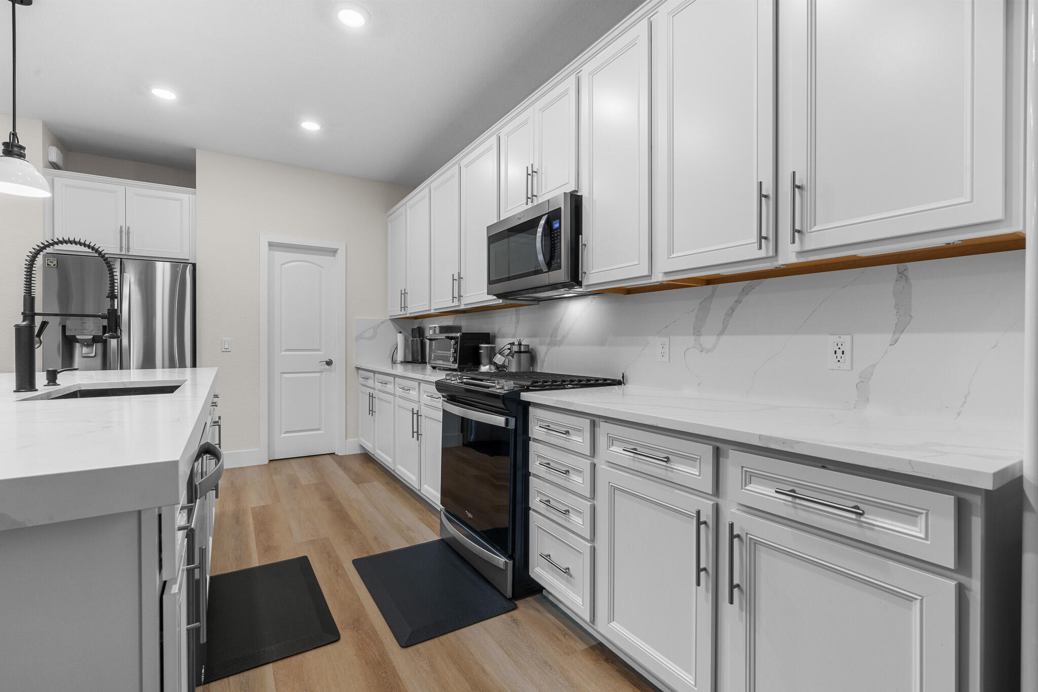 8202 Cadre Noir Road Lake Worth, FL 33467 - Photo 4 of 58 a kitchen with stainless steel appliances granite countertop a stove a sink and a refrigerator with white cabinets