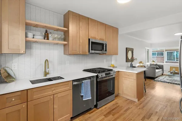 a kitchen with stainless steel appliances granite countertop a sink stove and microwave