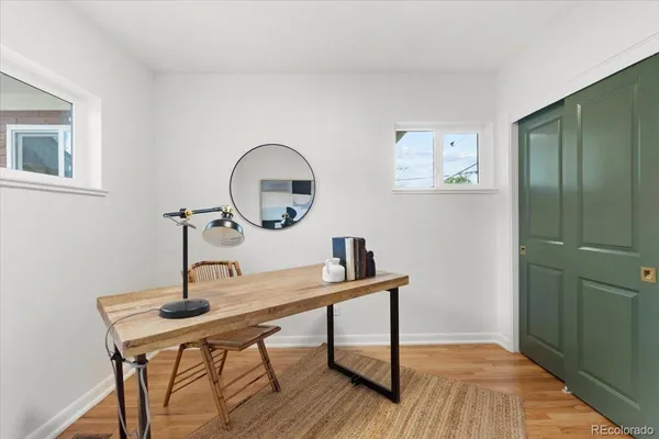 a view of a workspace room with wooden floor table and chair