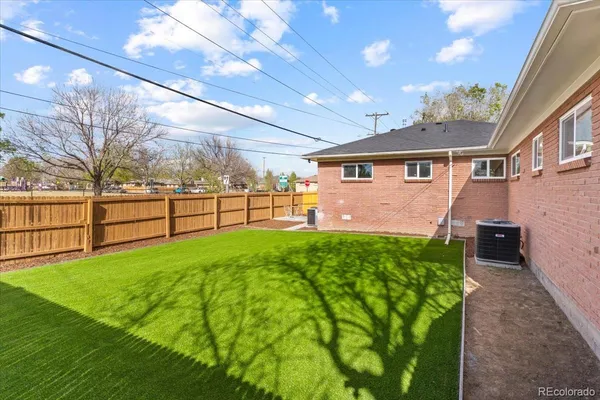 a view of a backyard with plants and large trees