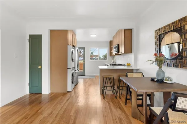 a kitchen with stainless steel appliances granite countertop a refrigerator a stove a sink dishwasher and white cabinets with wooden floor