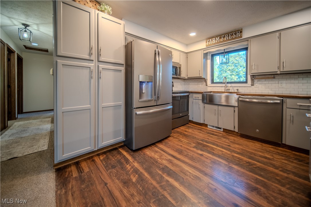 3459 Laubert Road Atwater, OH 44201 - Photo 12 of 39 Kitchen with appliances with stainless steel finishes, gray cabinets, tasteful backsplash, and dark wood-style flooring