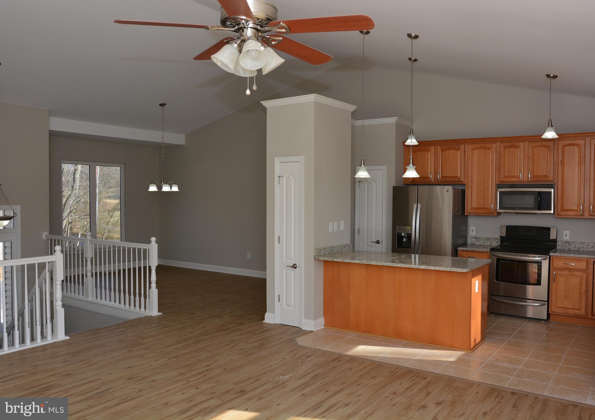 11231 Rawhide Road Lusby, MD 20657 - Photo 3 of 18 an open kitchen with wooden floor and stainless steel appliances