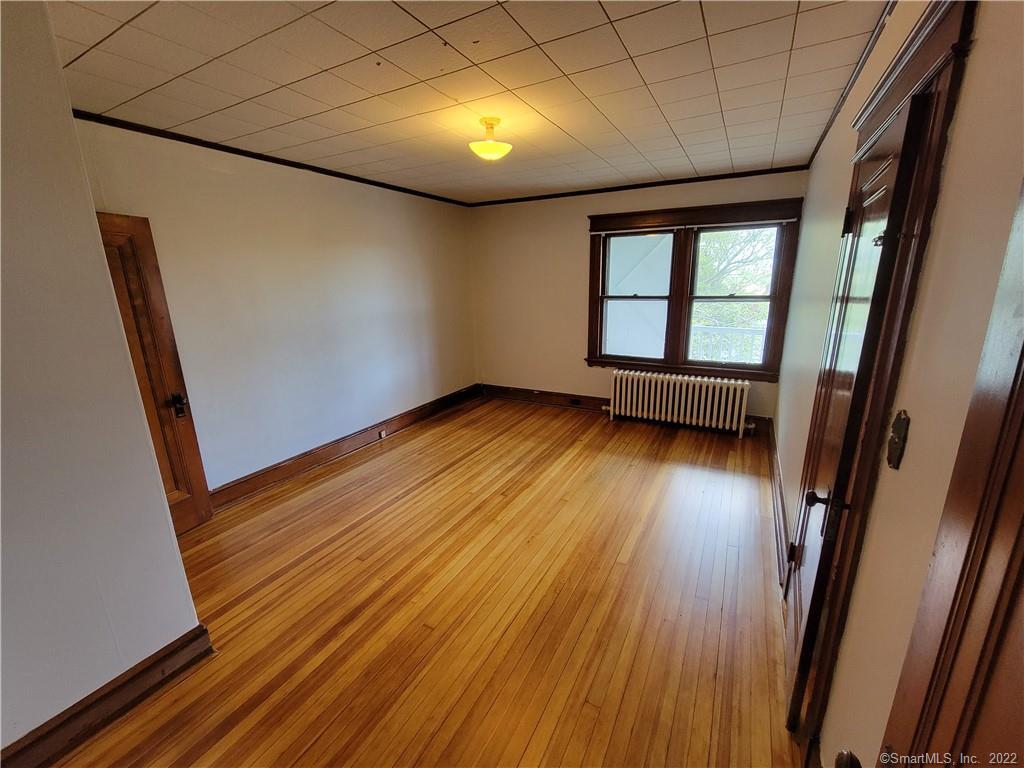 393 Highland Avenue, Unit 3 Waterbury, CT 06708 - Photo 4 of 10 a view of empty room with wooden floor and fan