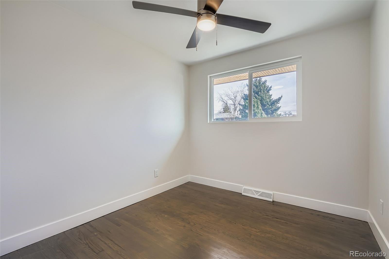 8771 Rutgers Street Westminster, CO 80031 - Photo 12 of 25 an empty room with wooden floor ceiling fan and window