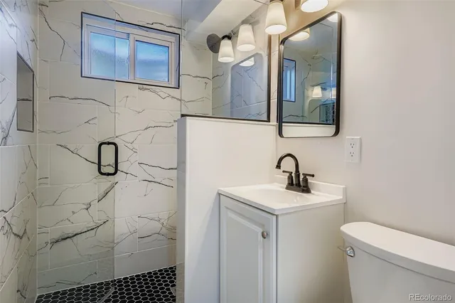 a bathroom with a sink toilet and mirror
