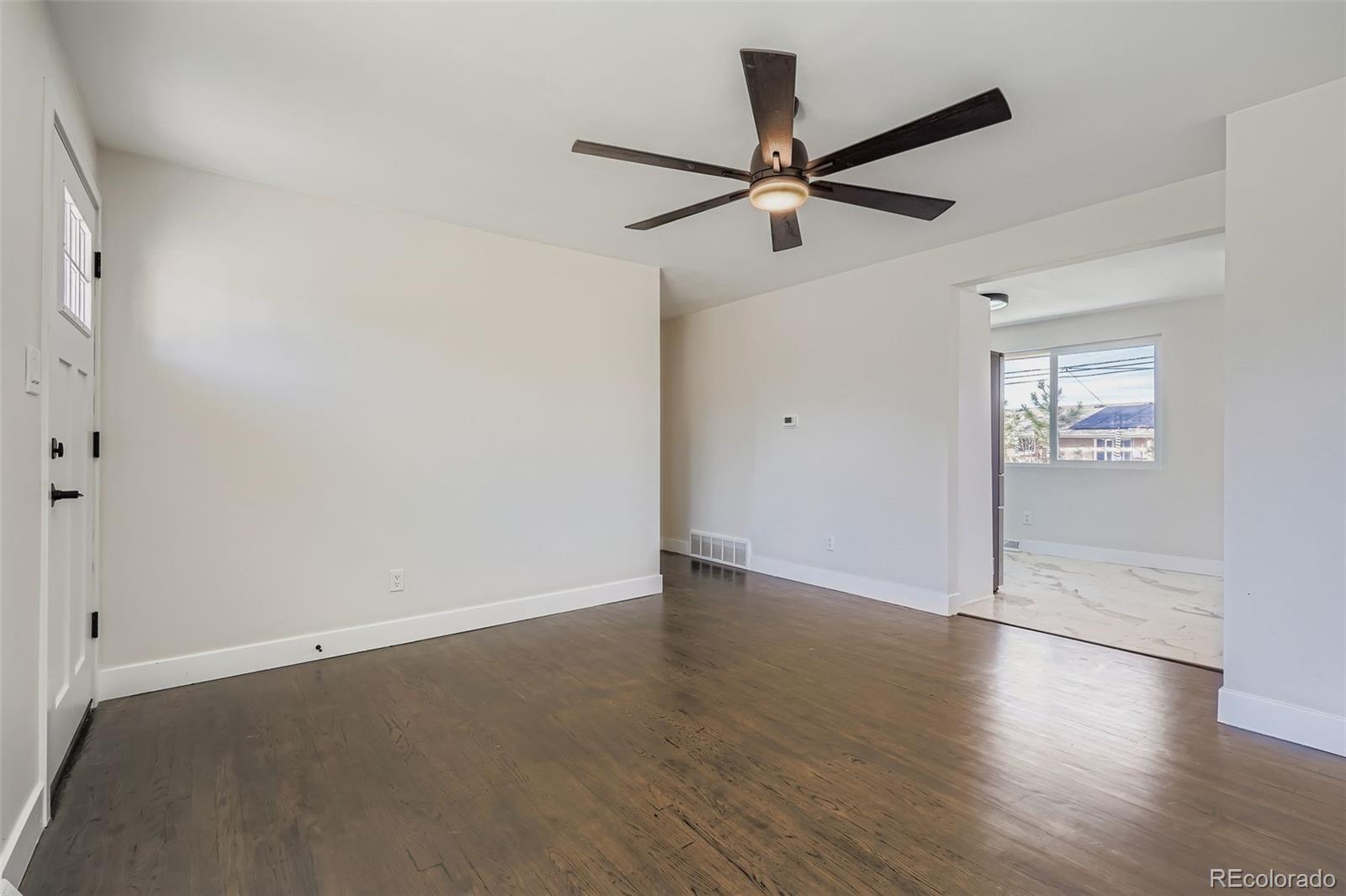 8771 Rutgers Street Westminster, CO 80031 - Photo 5 of 25 an empty room with wooden floor fan and windows
