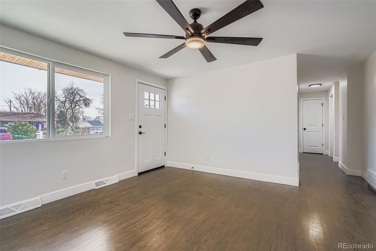 8771 Rutgers Street Westminster, CO 80031 - Photo 7 of 25 a view of an empty room with a window and wooden floor