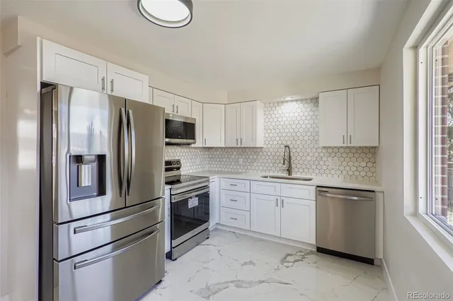 a kitchen with stainless steel appliances granite countertop a refrigerator sink and stove