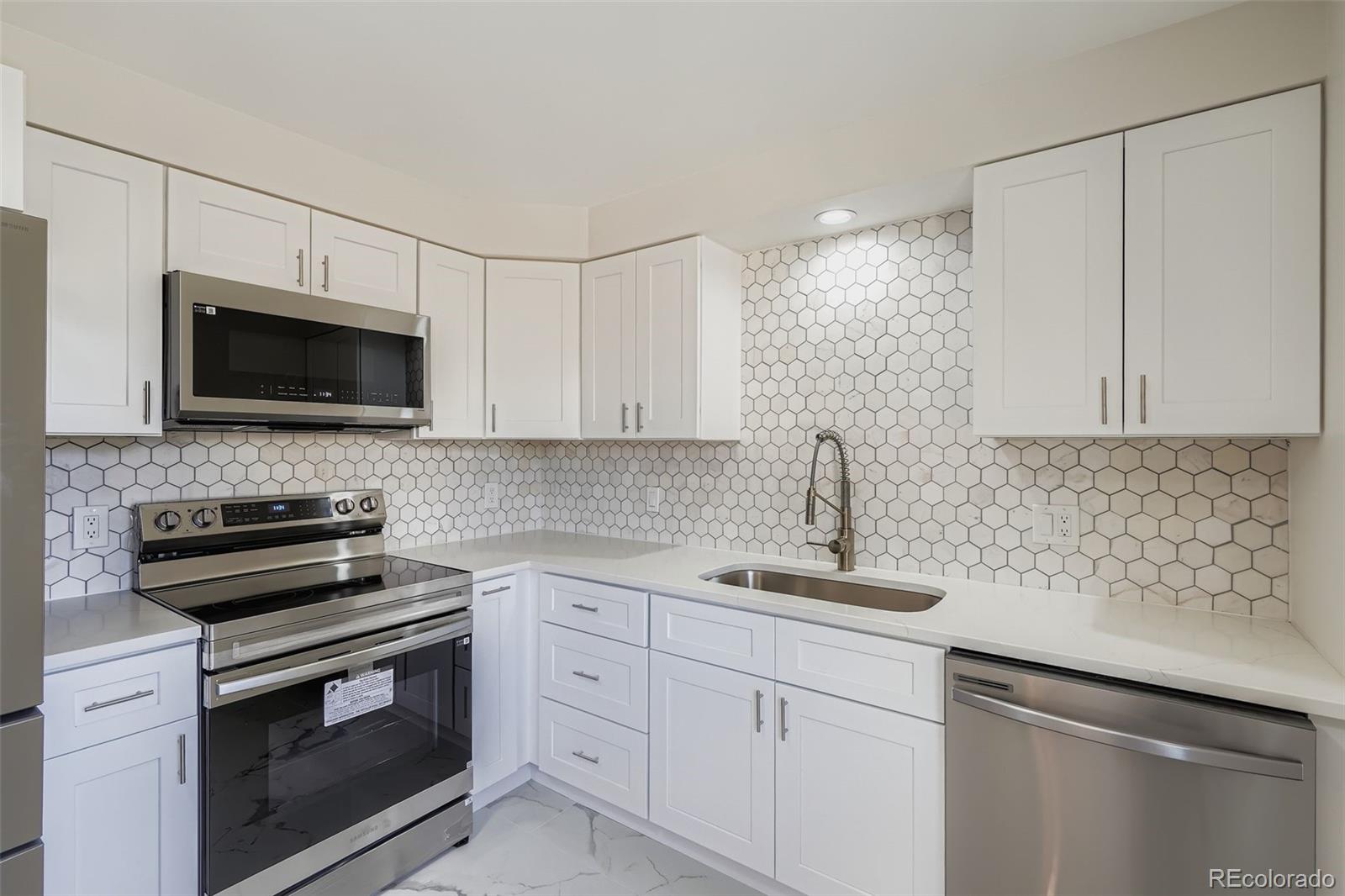 8771 Rutgers Street Westminster, CO 80031 - Photo 9 of 25 a kitchen with a sink stove and microwave