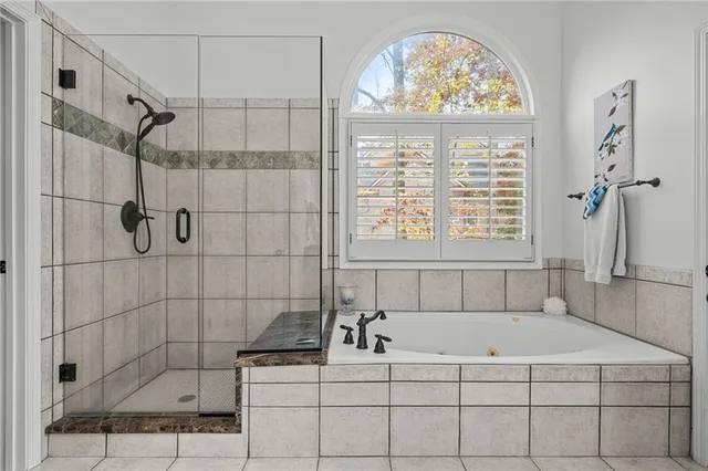 a bedroom with a bed and large window with wooden floor