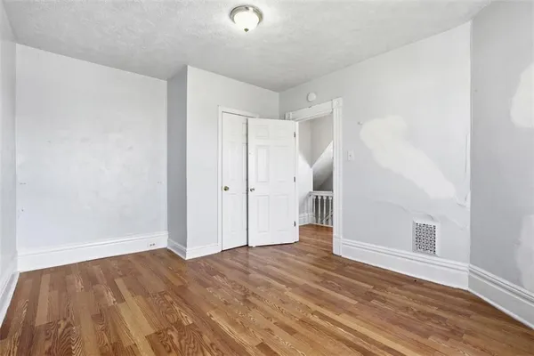 a view of empty room with wooden floor