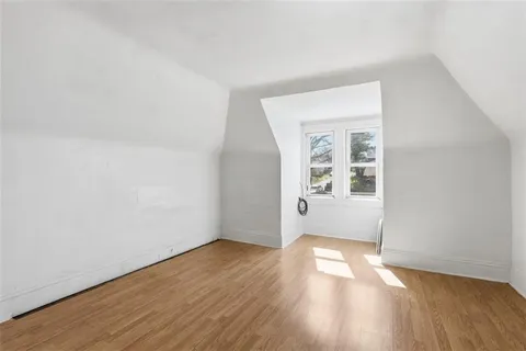 a view of a room with wooden floor and white walls