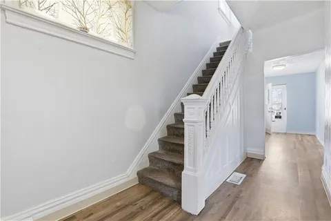 a view of a hallway with wooden floor and entryway