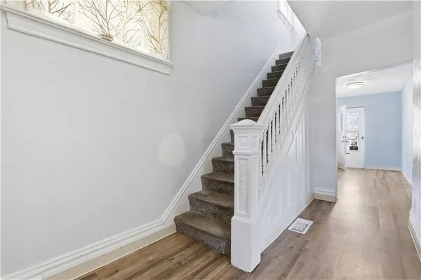 a view of a hallway with wooden floor and entryway