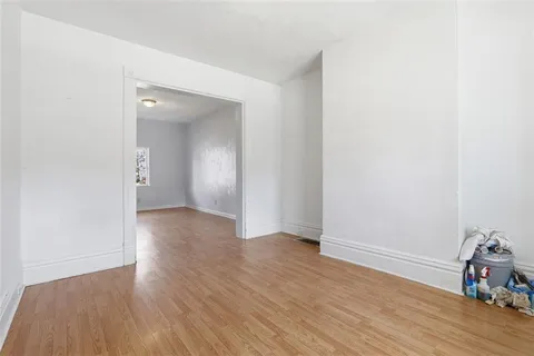 an empty room with wooden floor and closet