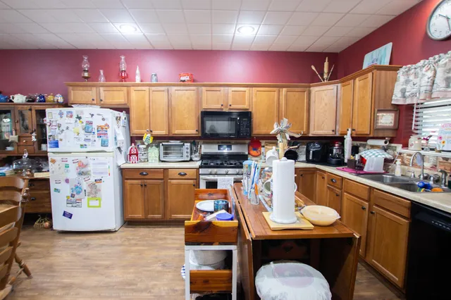 a room with stainless steel appliances furniture and a kitchen view