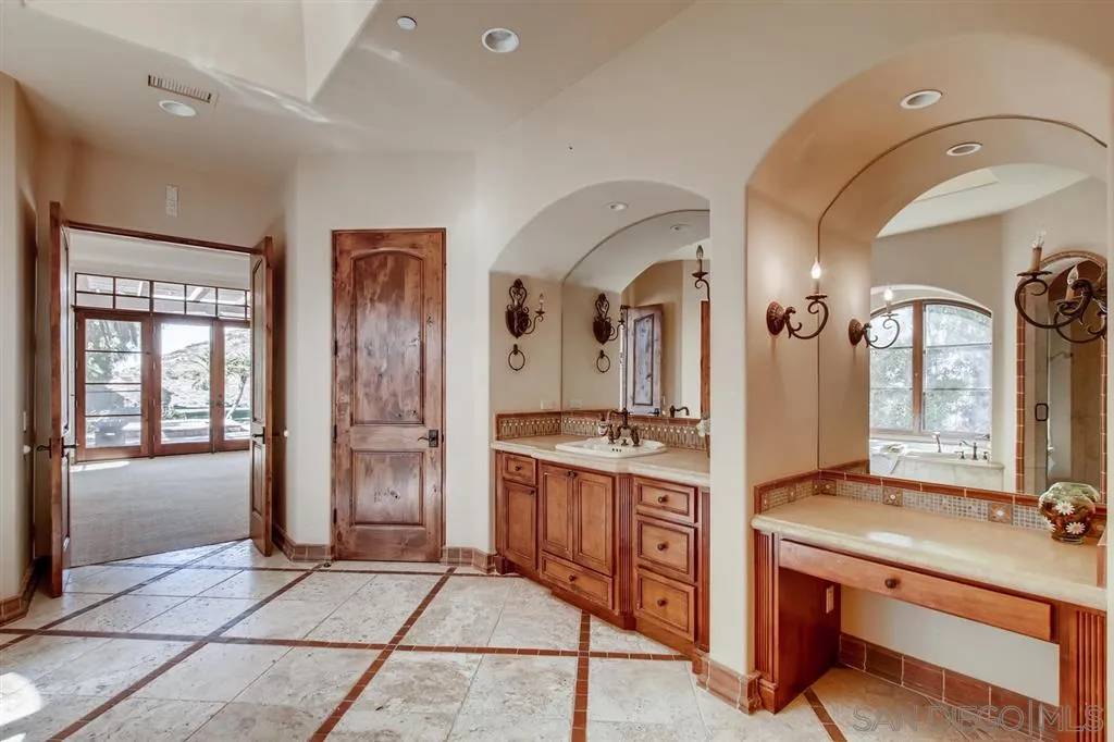 14160 Bryce Point Poway, CA 92064 - Photo 13 of 25 a hall with a sink and a large mirror