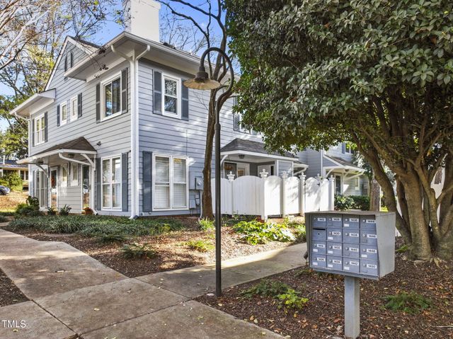 a front view of a house with a yard and tree