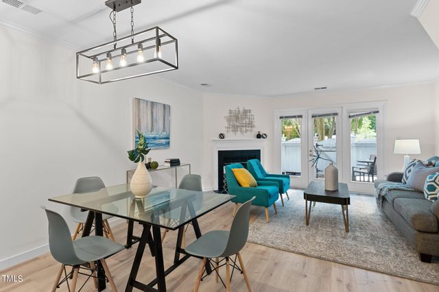 a view of a dining room with furniture a livingroom and chandelier