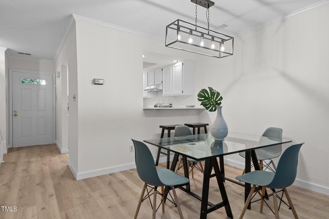 a view of a dining room with furniture a chandelier and wooden floor