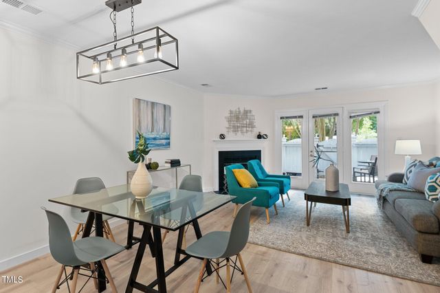 a view of a dining room with furniture a livingroom and chandelier