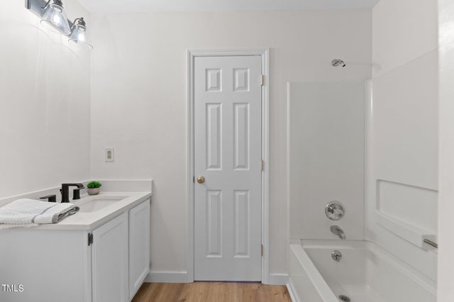 a bathroom with a tub sink and vanity