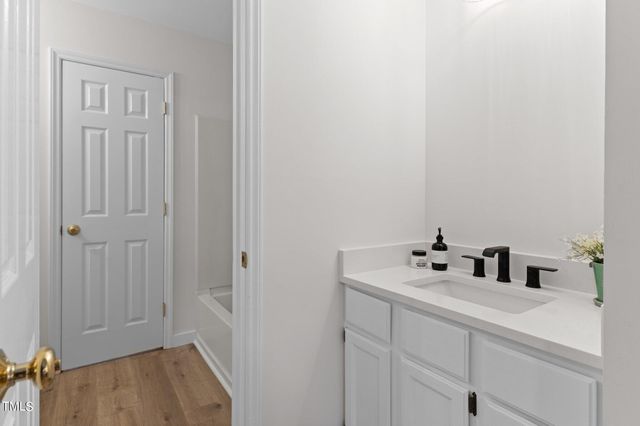 a walk in closet with wooden floor