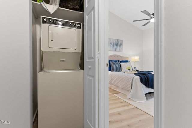 a walk in closet with wooden floor