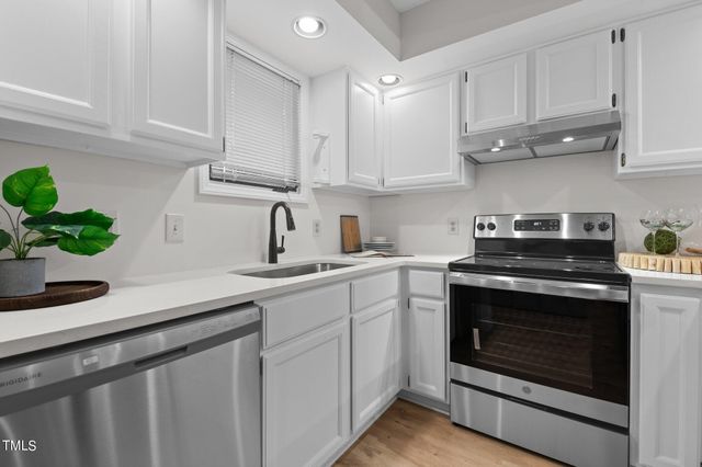 a kitchen with white cabinets stainless steel appliances and sink