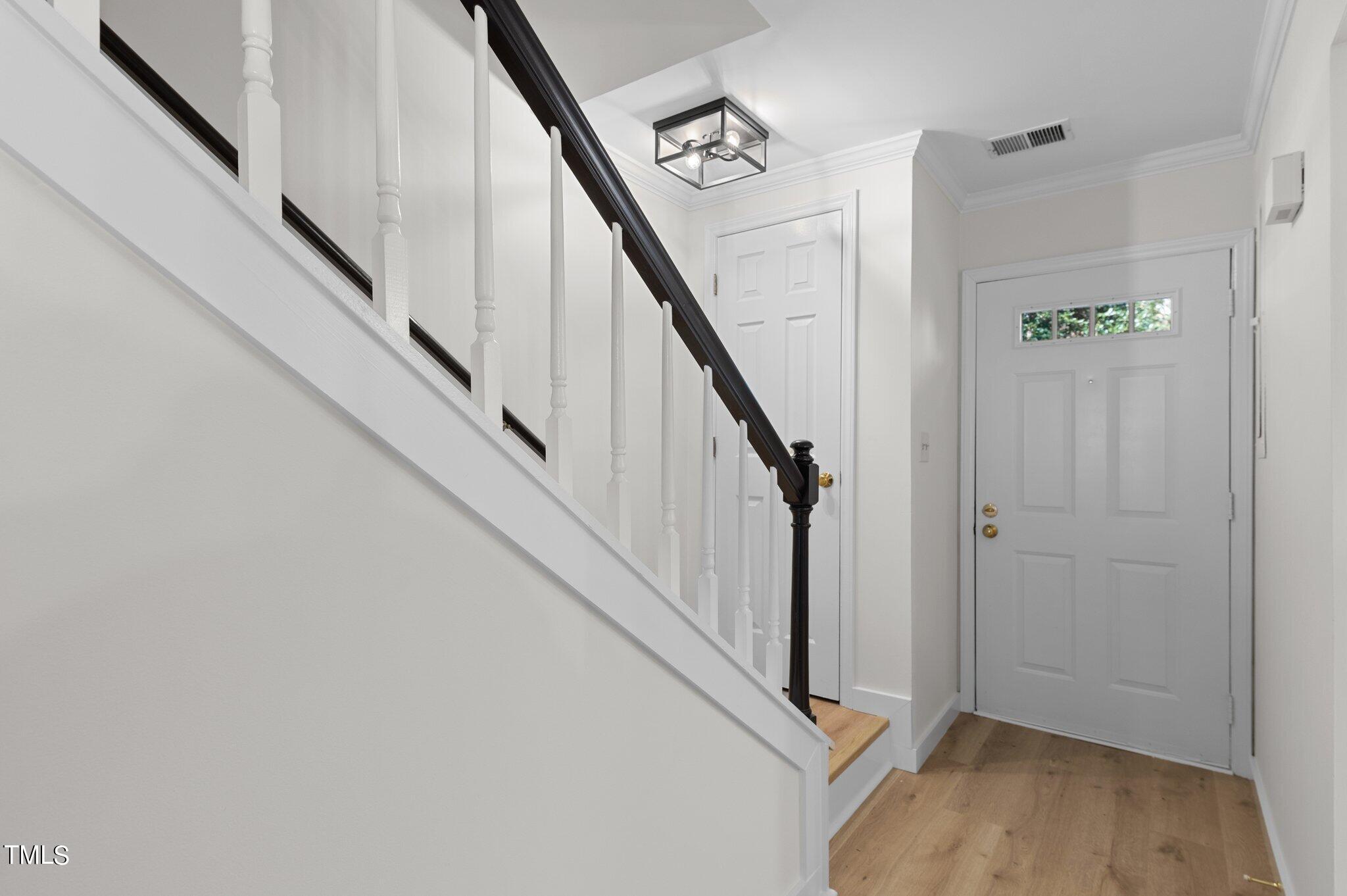 1440 Barton Pl Drive Raleigh, NC 27608 - Photo 9 of 57 a view of entryway with stairs and wooden floor