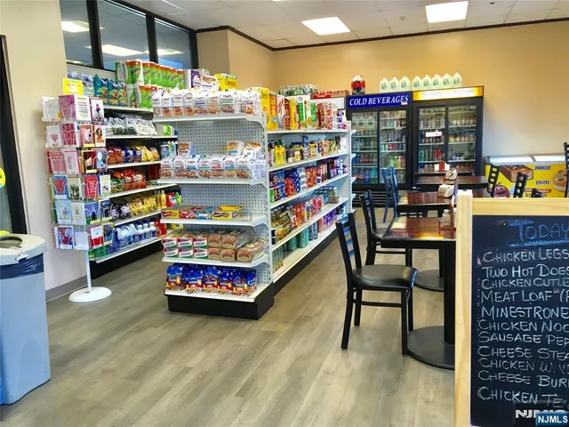 a store room with stainless steel appliances a dining table and chairs