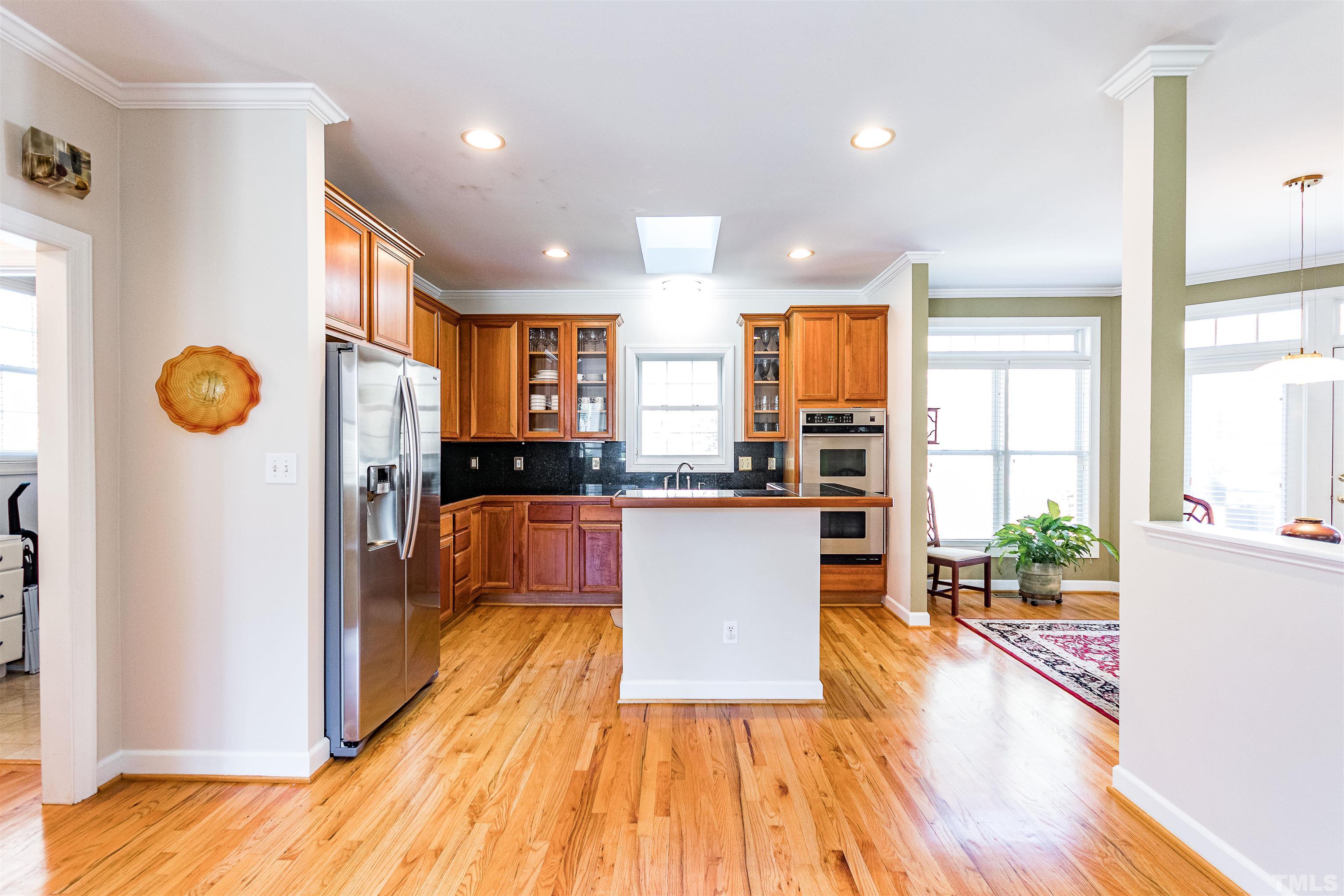 3324 Edgemont Drive Raleigh, NC 27612 - Photo 12 of 29 a kitchen with stainless steel appliances granite countertop a refrigerator a stove top oven and a sink with wooden floor