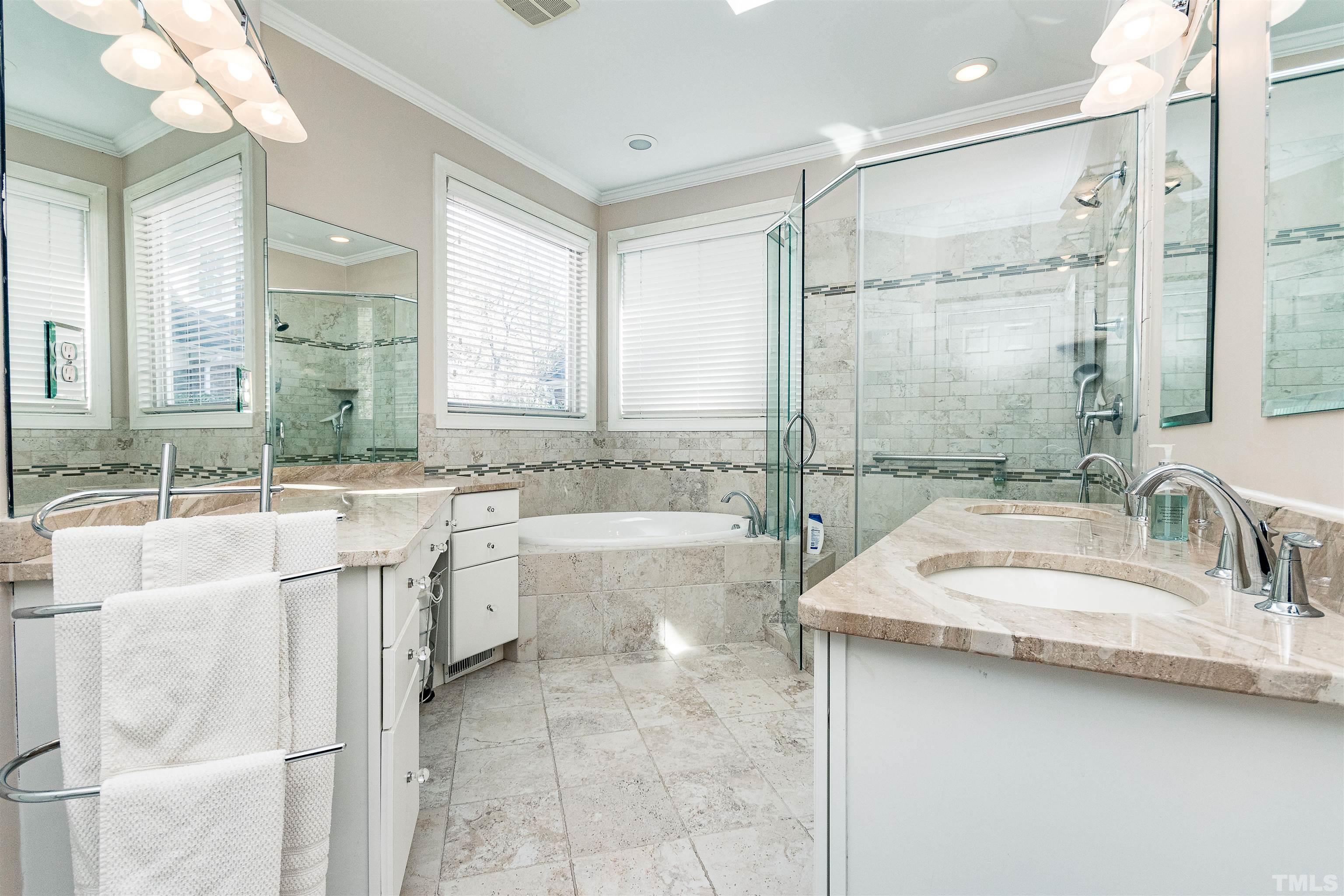 3324 Edgemont Drive Raleigh, NC 27612 - Photo 20 of 29 a bathroom with a double vanity sink large mirror and a bathtub