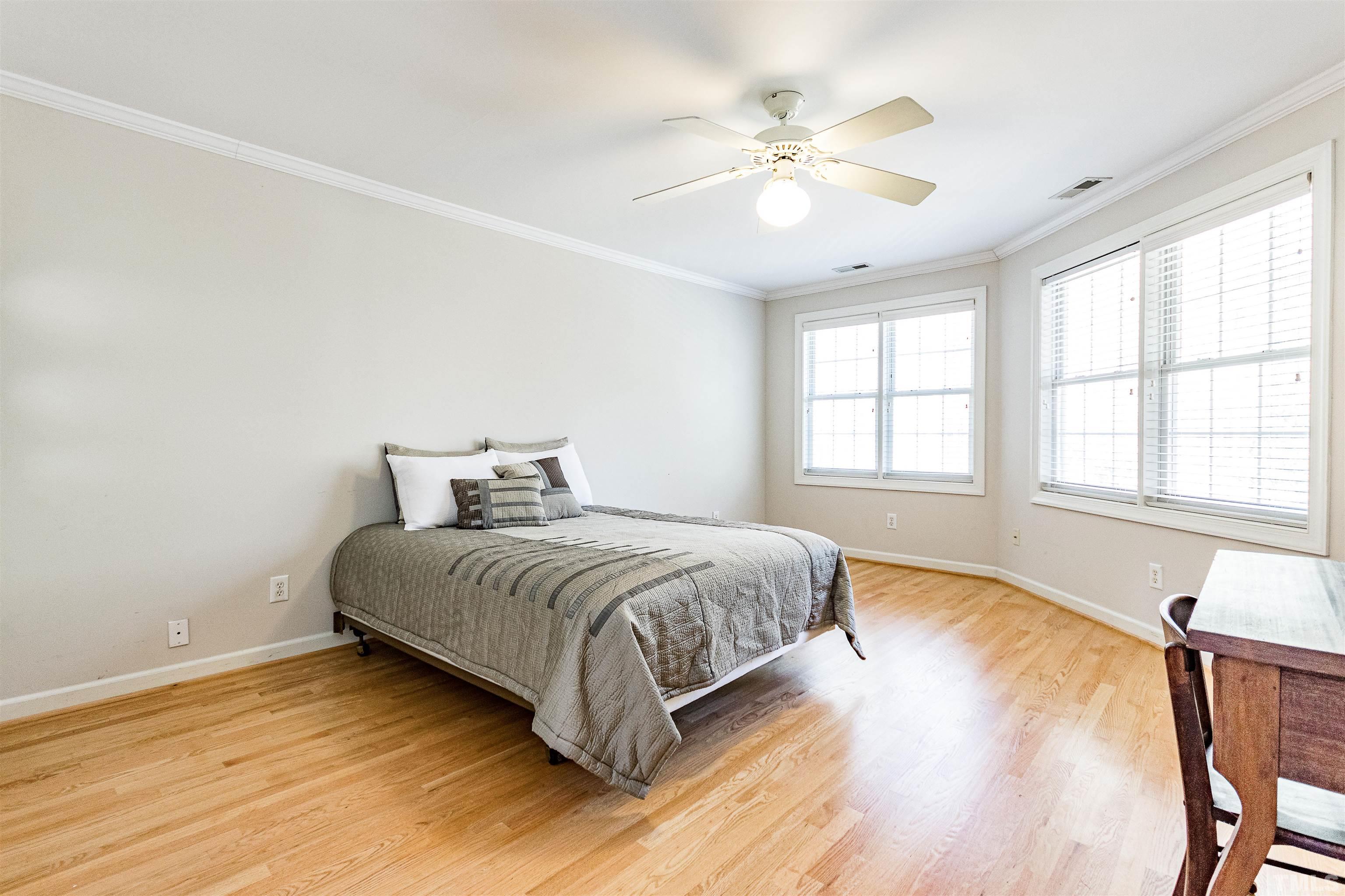 3324 Edgemont Drive Raleigh, NC 27612 - Photo 23 of 29 a spacious bedroom with a bed and a chandelier