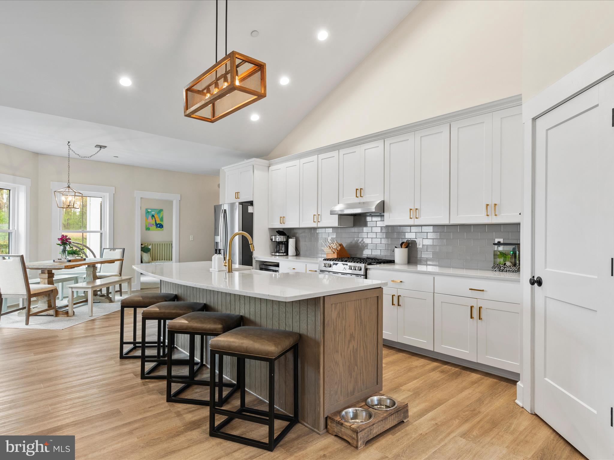 9741 Mason Road Berlin, MD 21811 - Photo 17 of 71 a kitchen with stainless steel appliances granite countertop a stove a sink dishwasher and a dining table with wooden floor