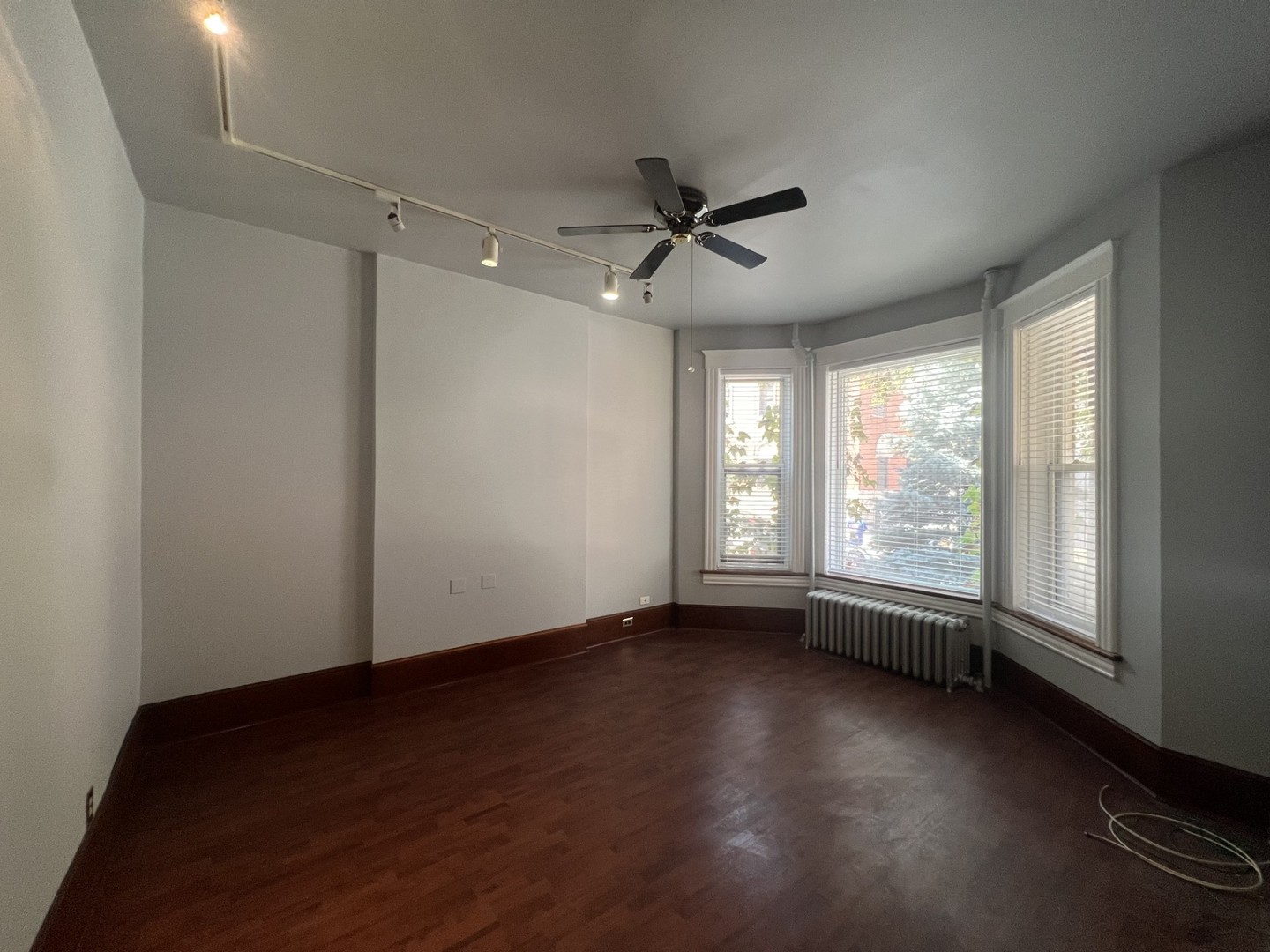 3545 North Sheffield Avenue, Unit 1 Chicago, IL 60657 - Photo 2 of 23 a view of an empty room with a window and wooden floor