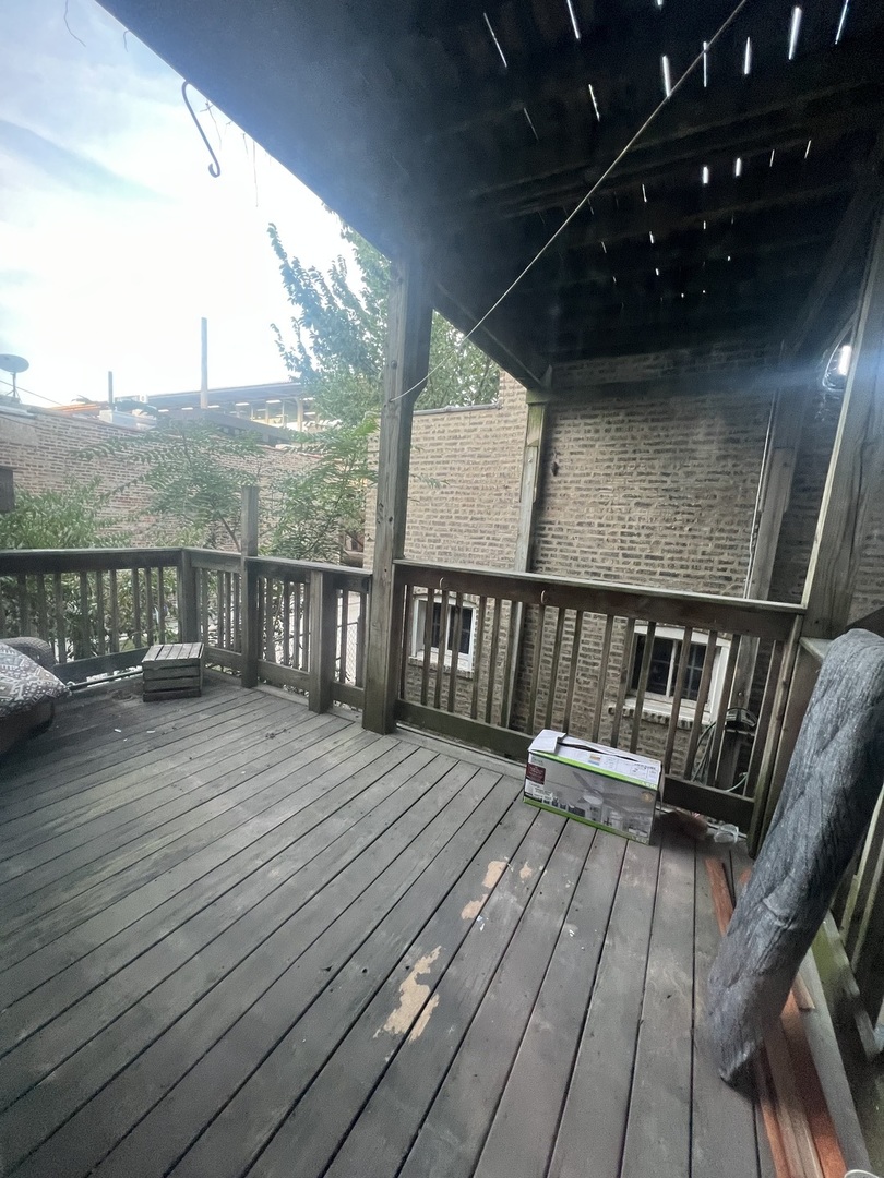3545 North Sheffield Avenue, Unit 1 Chicago, IL 60657 - Photo 22 of 23 a balcony with wooden floor table and chairs