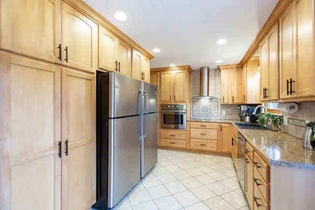 a kitchen with stainless steel appliances granite countertop a stove a sink and a microwave