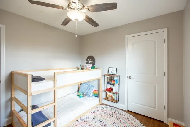 a view of a room with wooden floor and a ceiling fan
