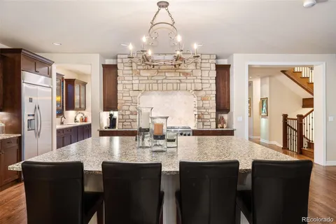 a kitchen with granite countertop a table chairs stove and cabinets