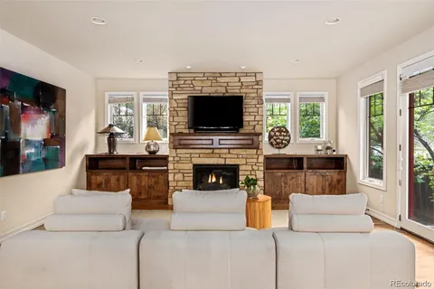 a living room with furniture a flat screen tv and a fireplace