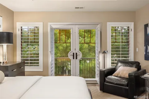 a bedroom with a bed a television and a large window