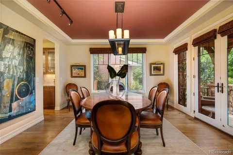a dining room with furniture a chandelier and wooden floor