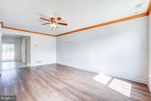a view of a room with wooden floor and white walls