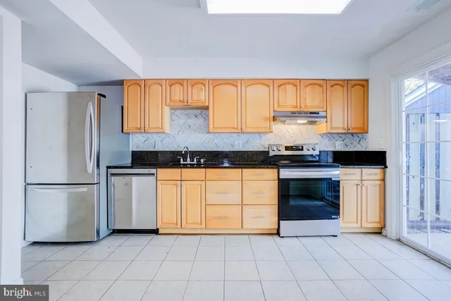 a kitchen with granite countertop a refrigerator and a sink
